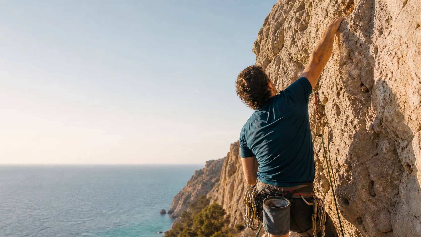 Profesional de actividades de aventura escalando junto al Mediterráneo